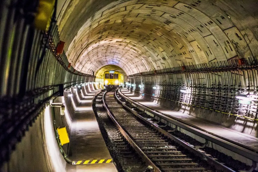A train track in the middle of an underground tunnel.